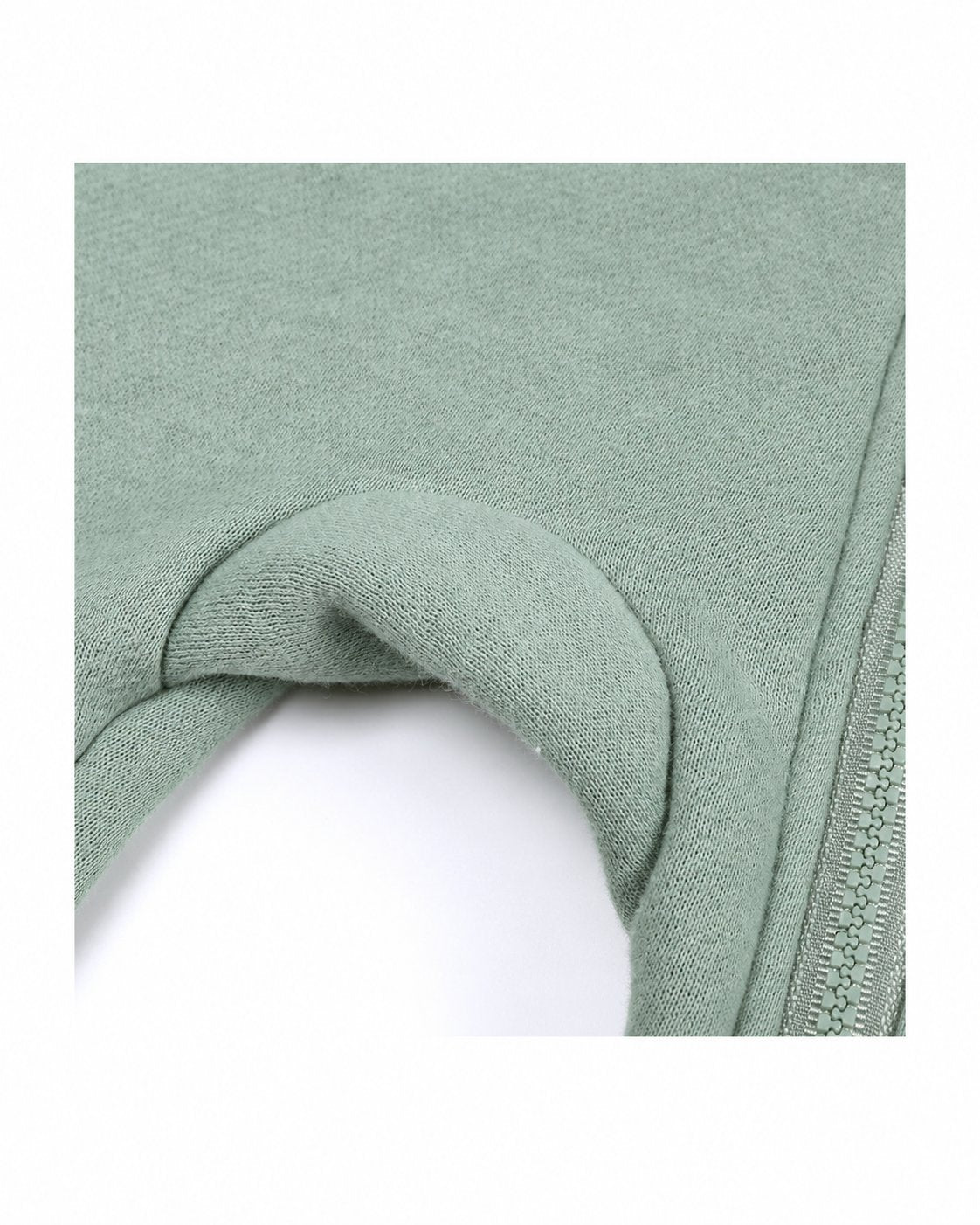 Close-up of sage green romper fabric and sleeve
