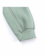 Close-up of the zipper and ribbed cuff on a sage green baby romper