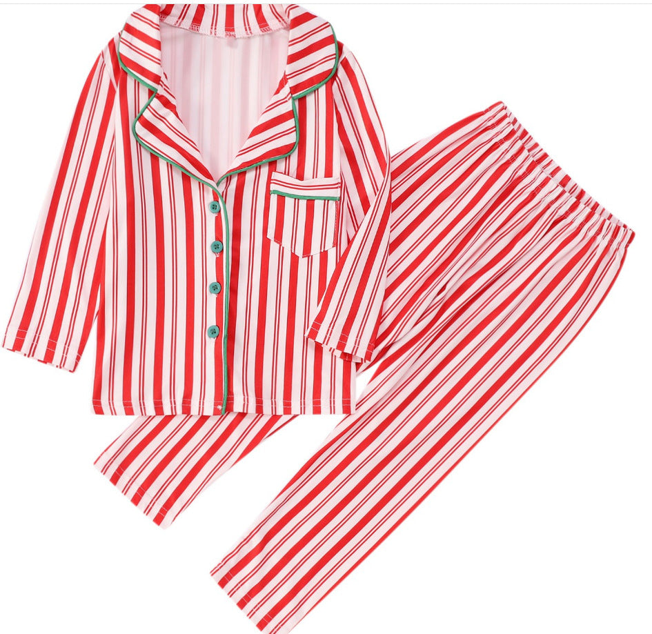 Flat lay view of a red and white candy cane striped adult 2-piece pajama set featuring a button-down shirt with green piping and matching pants.