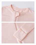 Neckline zipper guard and extended cuff details of a blush pink baby romper