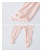 Enclosed feet and lower zipper detail of a blush pink baby romper