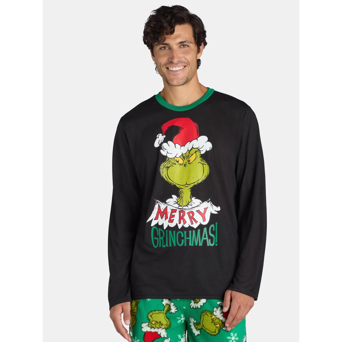 Front view of a man wearing a black Grinch Santa-hat top and green printed Christmas pajama pants
