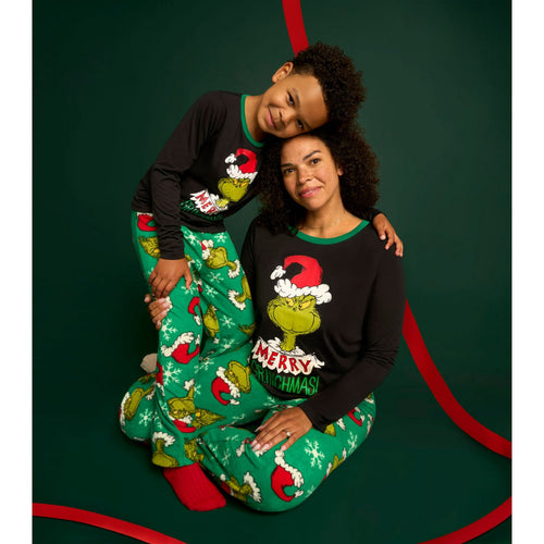 Mother and child wearing matching black Grinch tops and green Christmas pajama pants