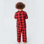 Back view of a curly-haired boy wearing red and black buffalo plaid pajamas.