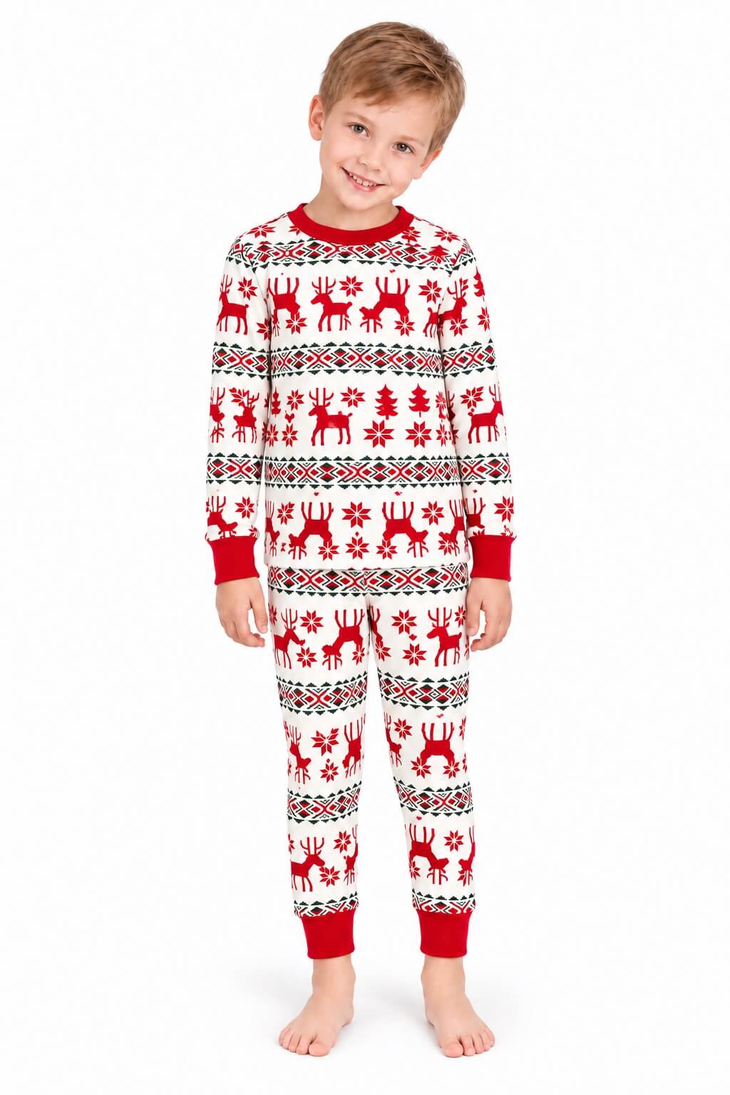 Boy wearing white Christmas pajamas with red reindeer, snowflakes and red cuffs against a white background.