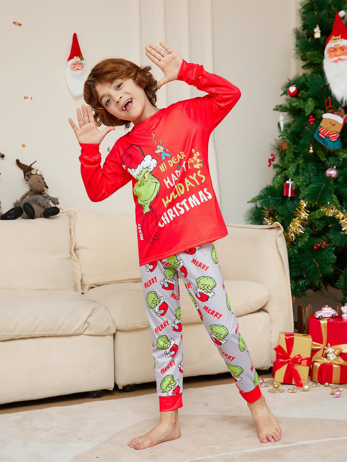 Boy posing playfully in a red Grinch top and light gray character-print pajama pants