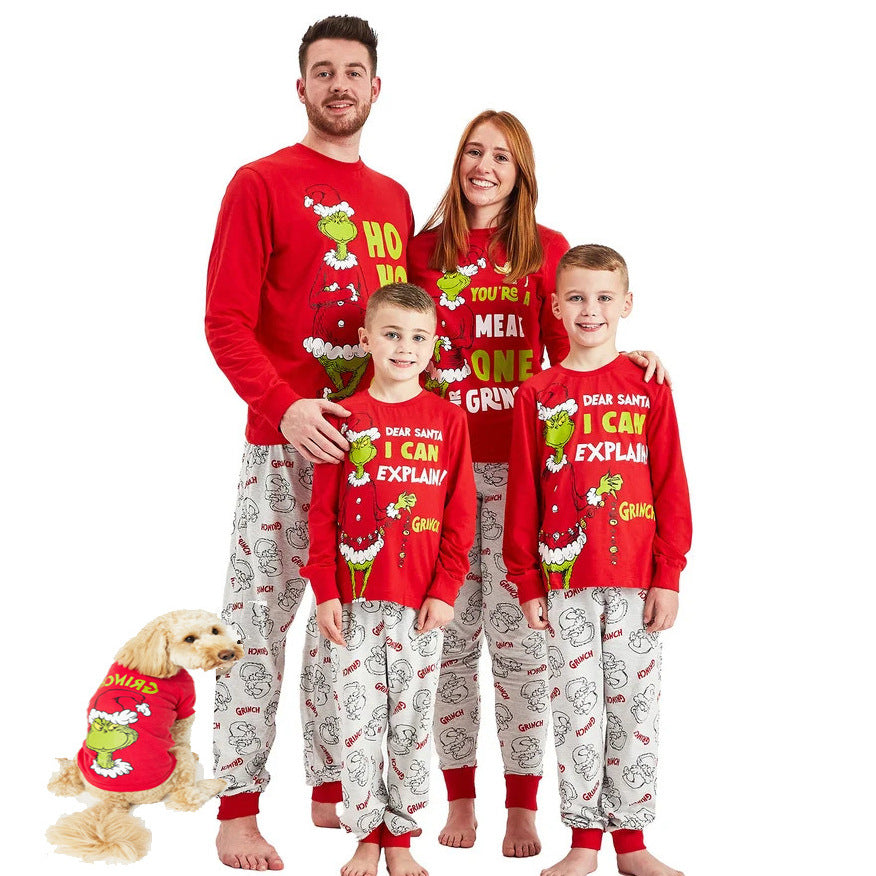 Family in red Grinch tops and light gray printed pants with a dog wearing a red Grinch shirt