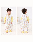 Toddler wearing the yellow Carnival split-leg sleep suit, showing front and back views