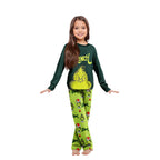 Girl wearing a dark green Grinch graphic top and lime-green printed Christmas pajama pants