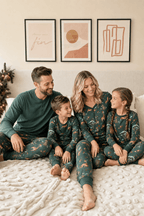 Family relaxing on a cream bed in teal animal-print pajamas, with dad wearing a solid teal Henley.