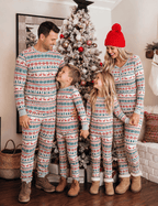Parents looking at their children beside a Christmas tree in grey pajamas with red and green Fair Isle motifs.
