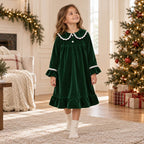 Girl wearing a green velvet long-sleeve nightgown with ruffle trim