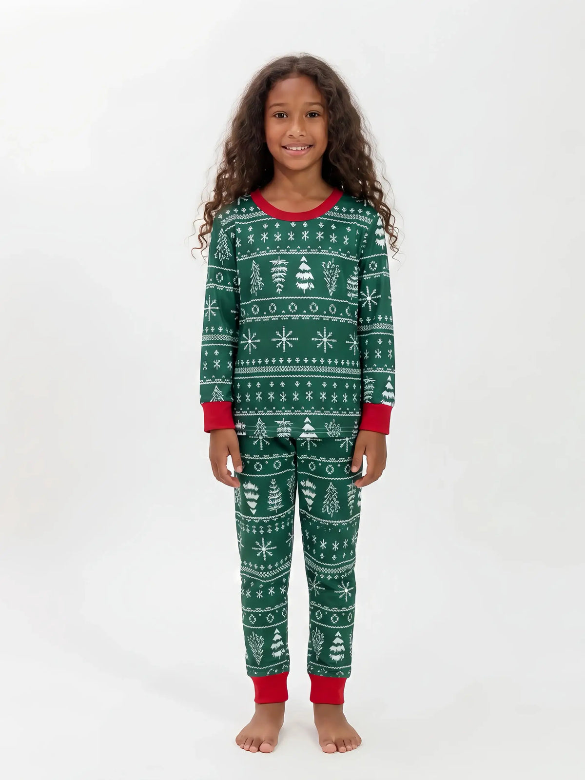 Girl wearing green Christmas pajamas with white snowflake and tree patterns, a red neckline and red cuffs.