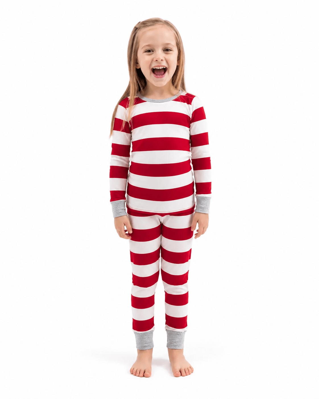 Girl modeling red and white wide-striped Christmas pajamas with grey cuffs against a white background.