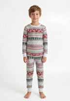 Boy with wavy hair modeling light grey Christmas pajamas with red reindeer bands, green trees and white cuffs.
