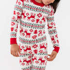 Detailed close-up shot of a kid wearing a long-sleeve red and white Fair Isle reindeer pajama top and matching pants.