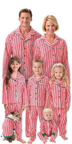Family of six with a pet dog wearing matching red and white candy cane striped Christmas pajama sets against a white background.