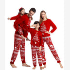 Playful full-length studio portrait of a family wearing matching red Christmas pajamas with Nordic polar bear pattern pants while the dad gives his daughter a piggyback ride on a white background.
