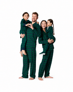 Family wearing forest green plaid matching Christmas pajamas.