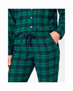 Close-up of forest green plaid pajamas showing buttons, drawstring waist and side pocket.