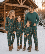 Family walking together outside a snowy cabin in green animal-print pajamas, with dad in a solid green Henley.