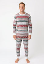Man wearing light grey Fair Isle Christmas pajamas with red reindeer, green trees and white neckline and cuffs.