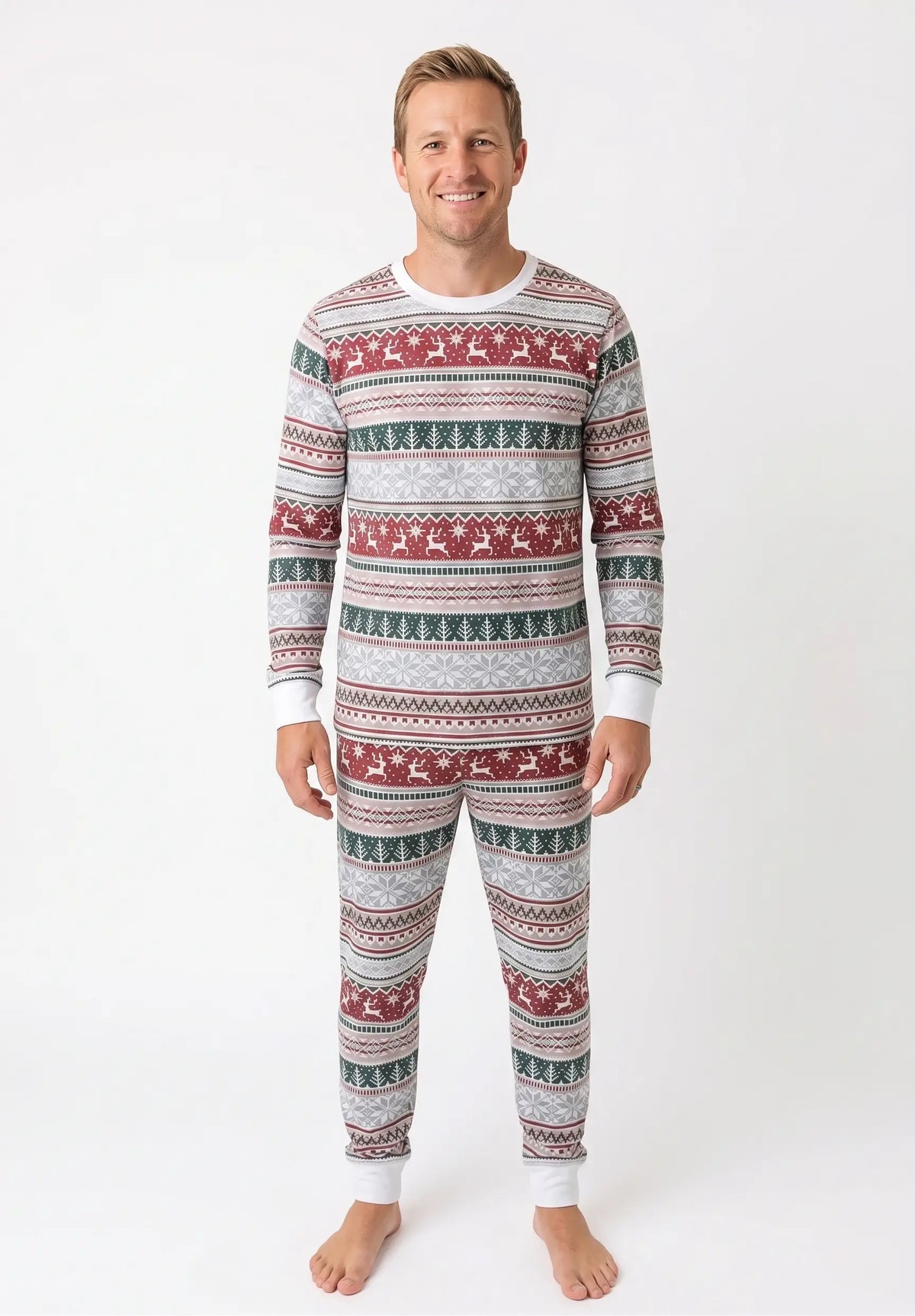 Man wearing light grey Fair Isle Christmas pajamas with red reindeer, green trees and white neckline and cuffs.