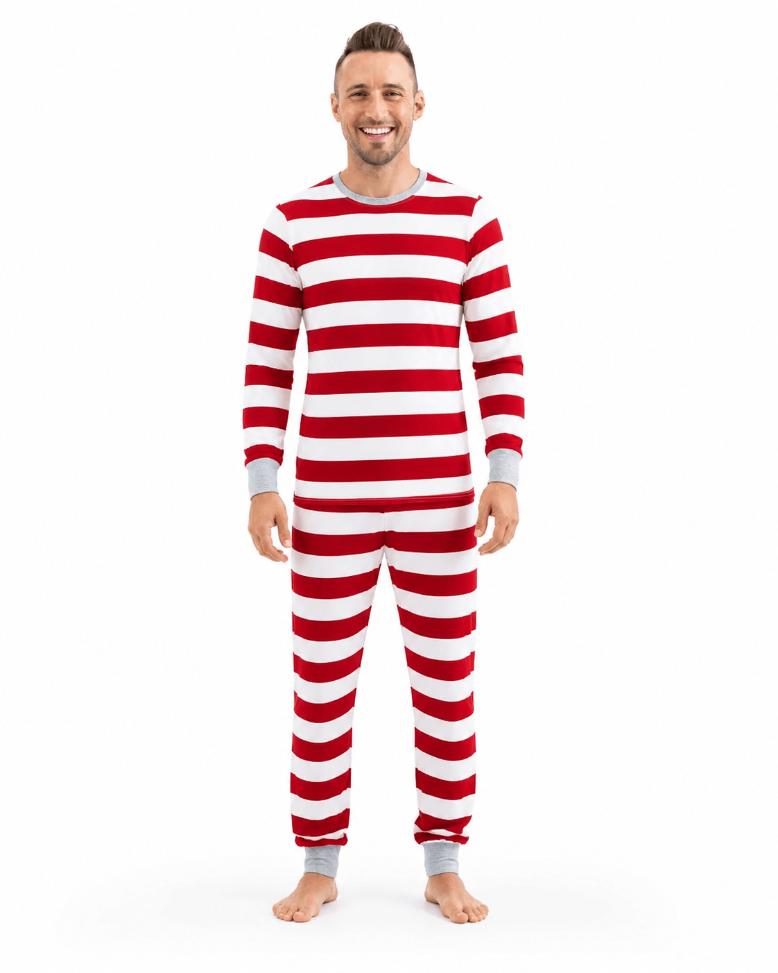 Man wearing red and white wide-striped Christmas pajamas with a grey crewneck and matching wrist and ankle cuffs.