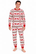 Man wearing white Christmas pajamas with red reindeer and snowflakes, a red crewneck and red cuffs.