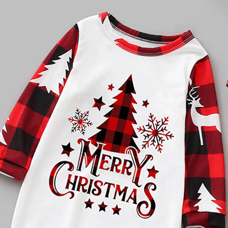 Close-up detail shot of the pajama chest graphic featuring Merry Christmas typography, a red buffalo check pine tree, snowflakes, and raglan sleeve stitching.