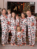 Large multi-generational family including grandparents, parents, and baby wearing matching red truck Christmas pajamas.