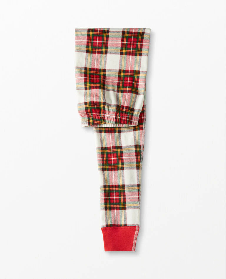 Detailed view of folded adult pajama pants featuring a traditional red, green, and cream plaid pattern with bright red ribbed ankle cuffs.