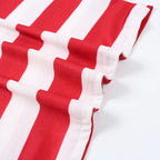 Close-up view of soft red and white striped cotton knit pajama fabric showing smooth texture and high-quality hem stitching.