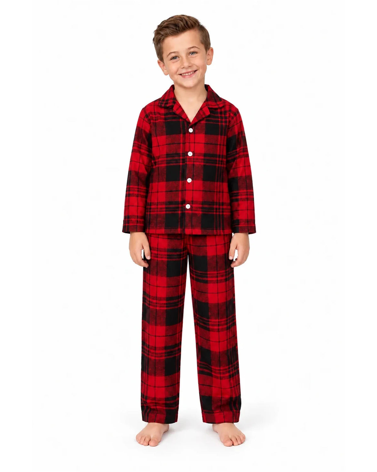Boy wearing a red and black plaid pajama shirt and long pants on a white background.