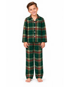 Boy wearing a light green tartan pajama shirt and long pants on a white background.