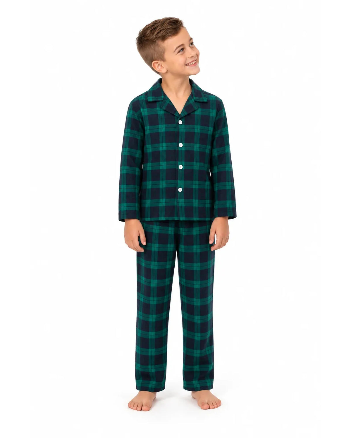 Boy wearing a green and black plaid pajama shirt and long pants on a white background.