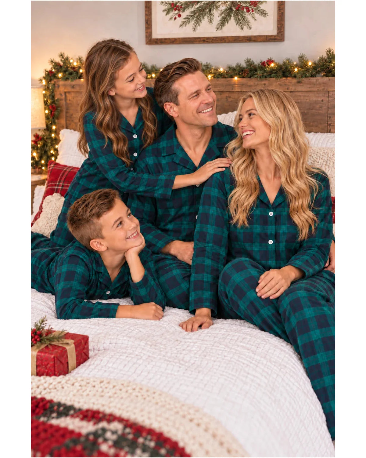 Family sitting together on a bed in matching green and black plaid pajamas.