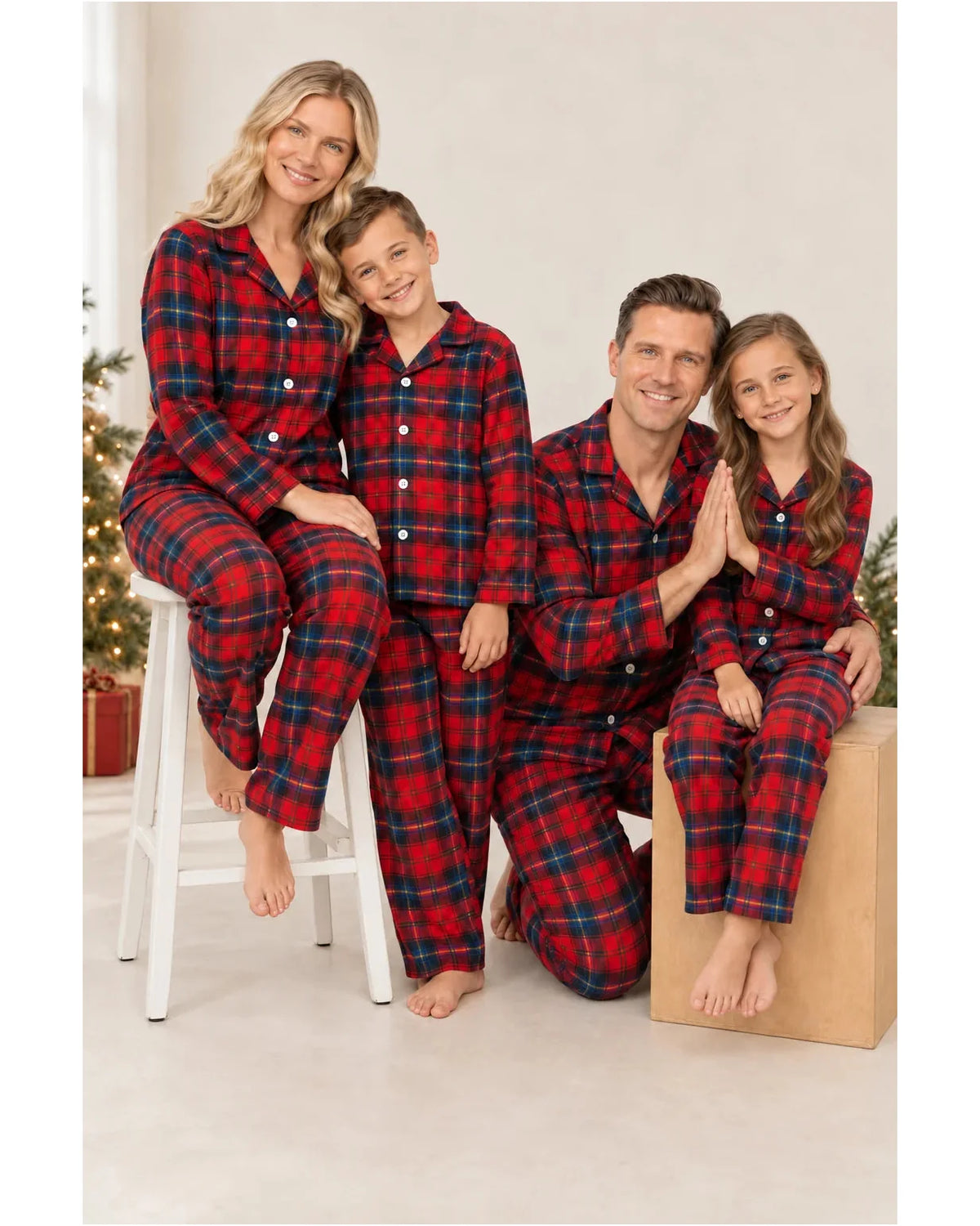 Adults and children wearing red and blue plaid pajama shirts and pants in a bright room.