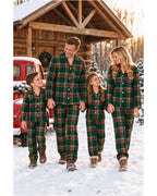 Family wearing light green tartan pajamas walking beside a red truck outside a snowy cabin.