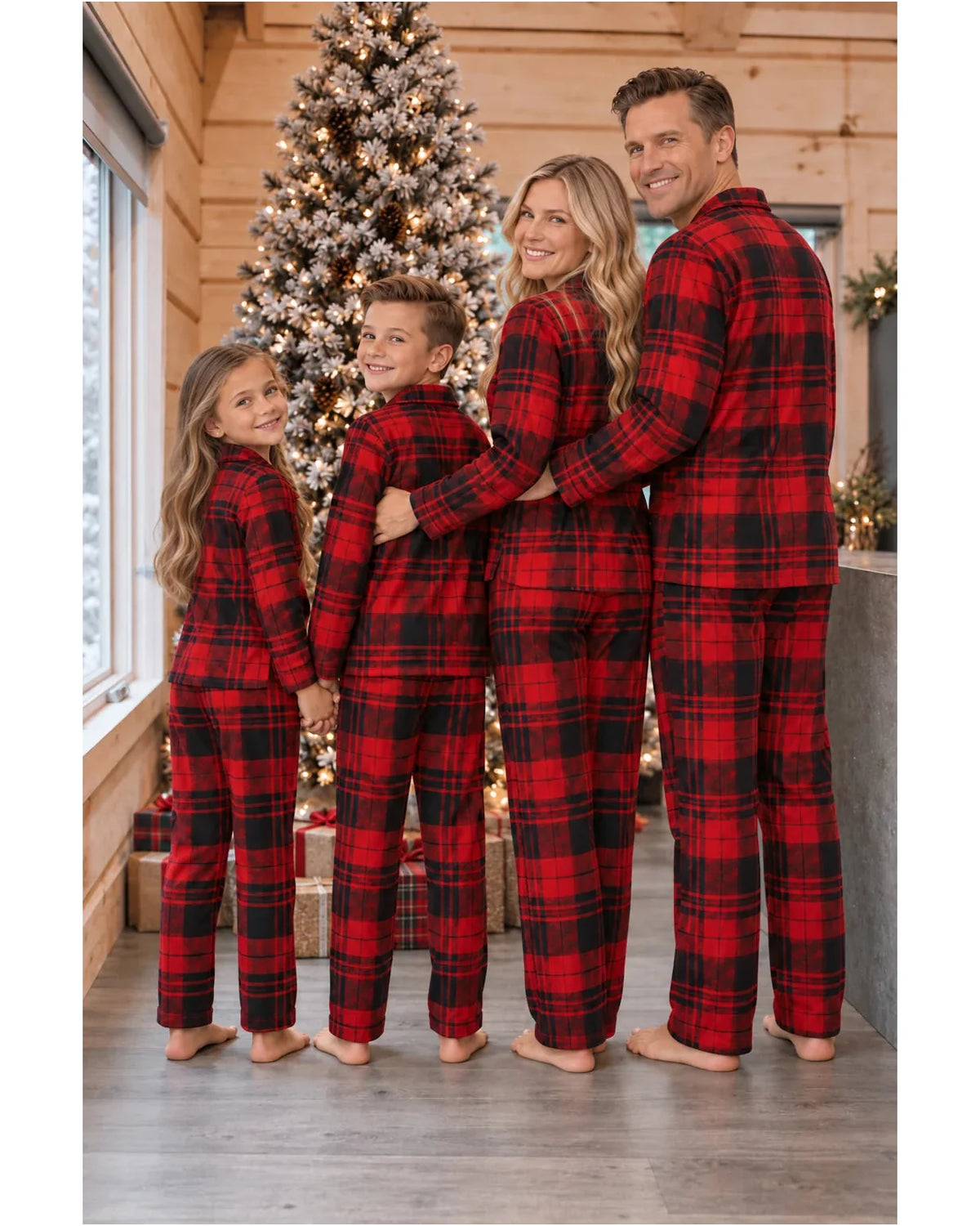 Rear view of a family wearing red and black plaid pajama shirts and pants beside a Christmas tree.
