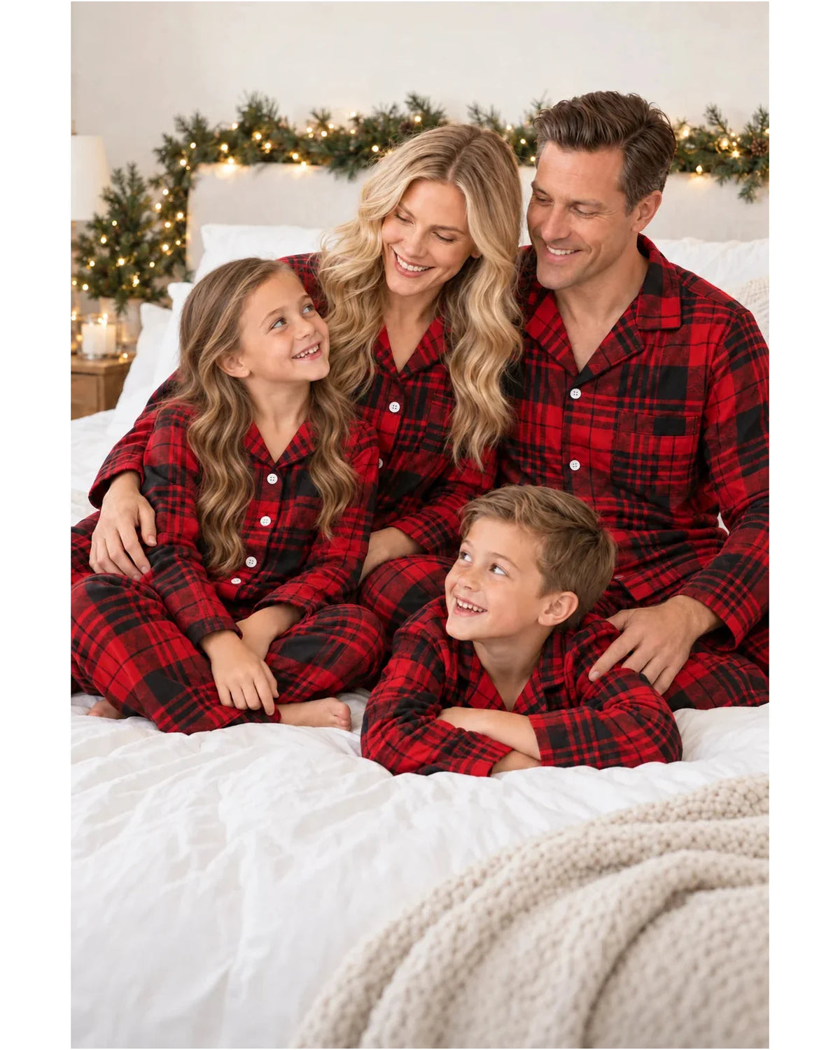 Close view of a family in red and black plaid pajamas sitting together on a bed.
