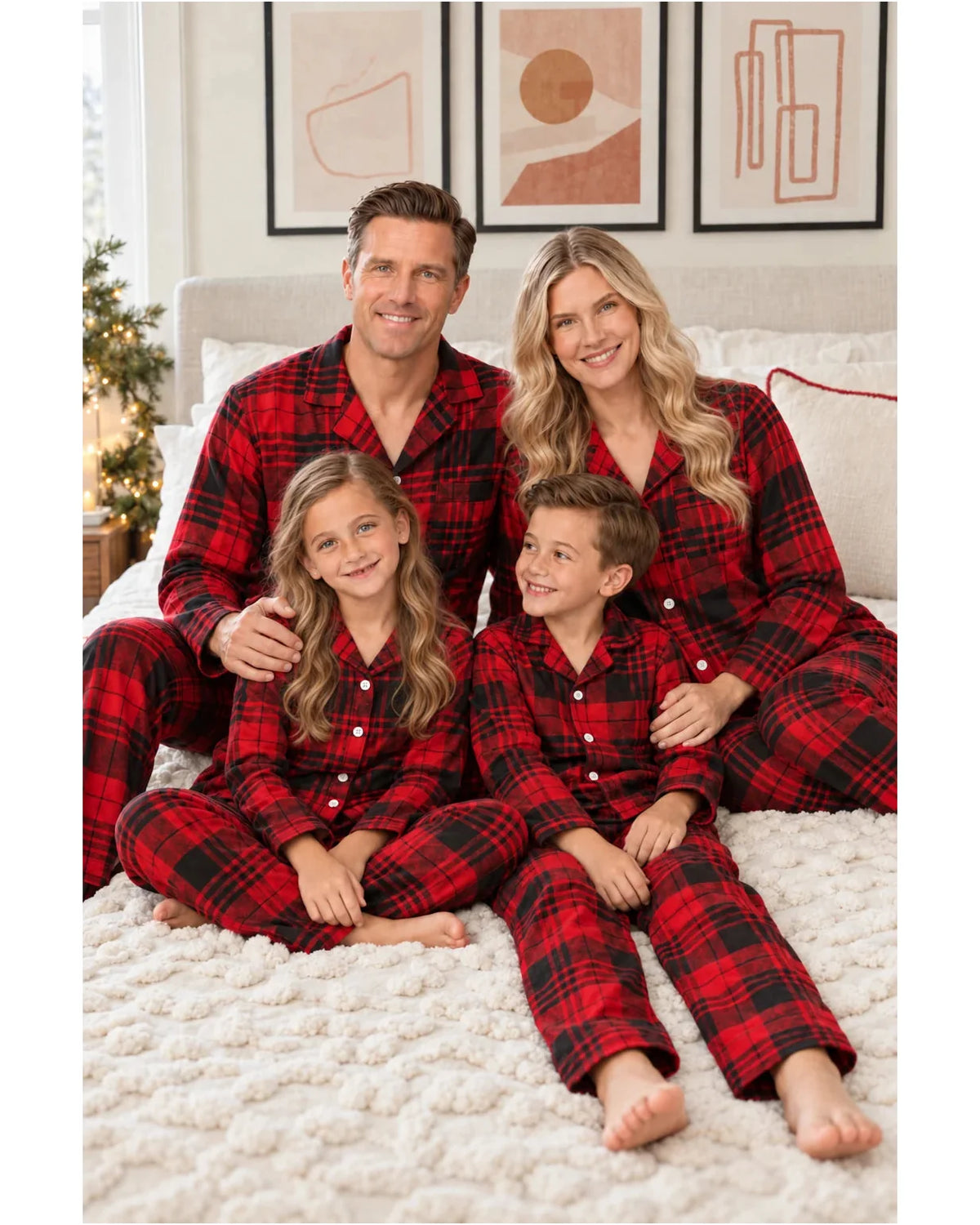 Family seated together on a textured bedspread in matching red and black plaid pajamas.