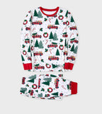 Flat lay display of a two-piece white Christmas pajama set featuring a classic red truck carrying a Christmas tree pattern.