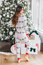 Back view of a woman wearing a white and red Fair Isle snowflake long-sleeve pajama set.