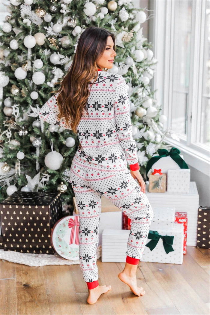 Back view of a woman wearing a white and red Fair Isle snowflake long-sleeve pajama set.
