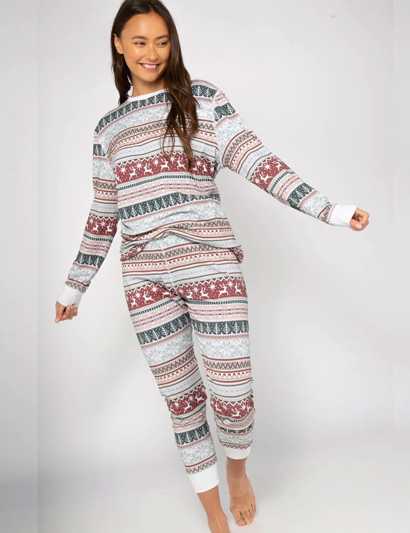 Female model posing in a women's long-sleeve grey Fair Isle reindeer print Christmas pajama set.