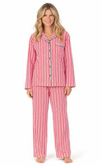 Woman wearing red and white vertical-striped button-up pajamas with green piping and buttons.
