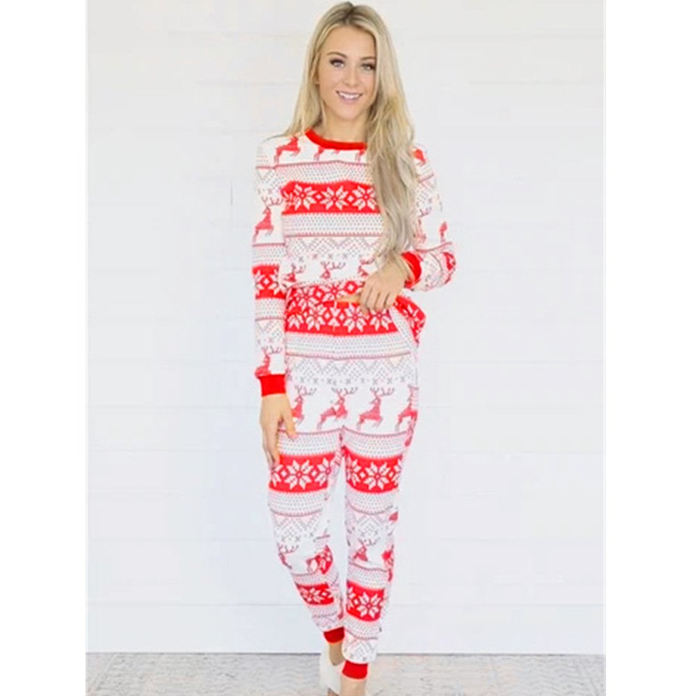 Front view studio shot of a smiling woman modeling the women's red and white Fair Isle reindeer Christmas pajamas against a bright white background.