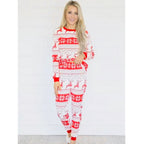 Front view studio shot of a smiling woman modeling the women's red and white Fair Isle reindeer Christmas pajamas against a bright white background.