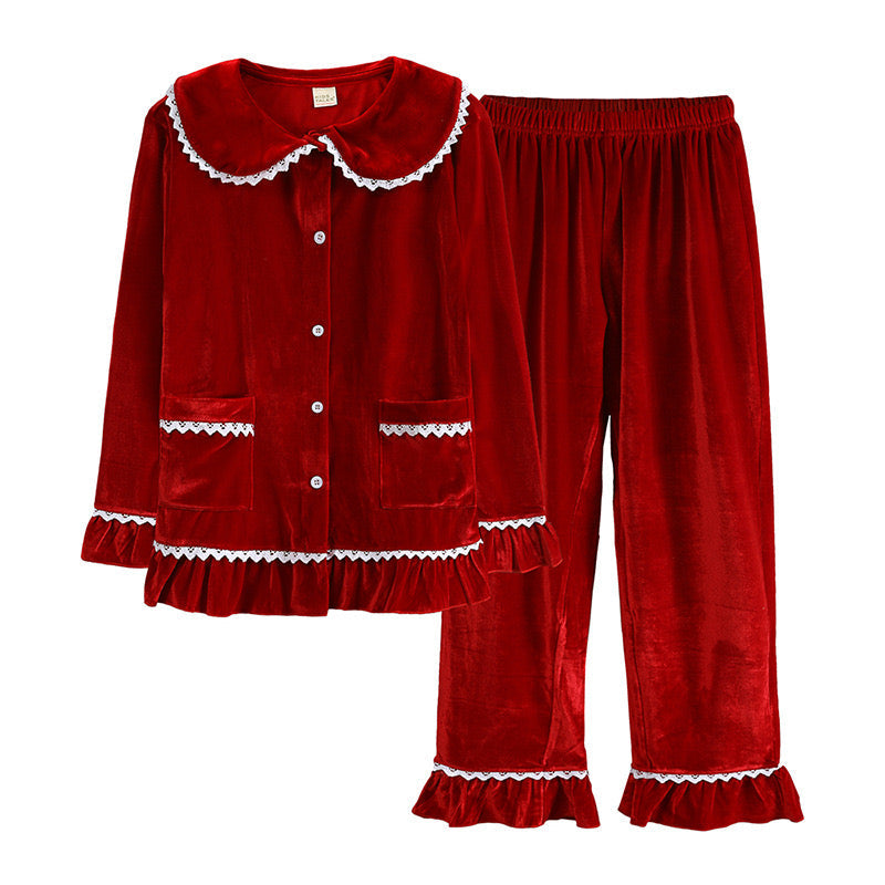 Red velvet women's pajama top and pants with white ruffle trim and front pockets, arranged flat on white.
